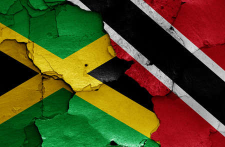 flags of Jamaica and Trinidad and Tobago painted on cracked wallの写真素材