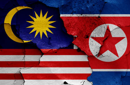 flags of Malaysia and North Korea painted on cracked wallの写真素材