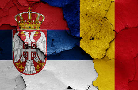 flags of Serbia and Romania painted on cracked wallの写真素材