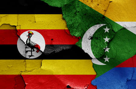 flags of Uganda and Comoros painted on cracked wallの写真素材