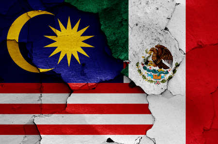 flags of Malaysia and Mexico painted on cracked wallの写真素材
