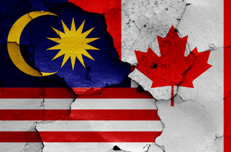 flags of Malaysia and Canada painted on cracked wallの写真素材