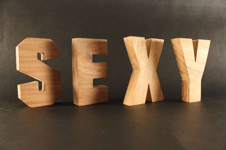 Sexy text from wood letters Holz Buchstaben black Backgroundの写真素材