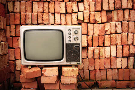 Old television nearby brick wallの写真素材