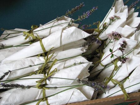 Several napkins sets bound together with twine sitting in a basket ready to be layed out for an event or celebration.の写真素材