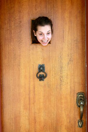 A young woman's head through a vintage door opening.の写真素材