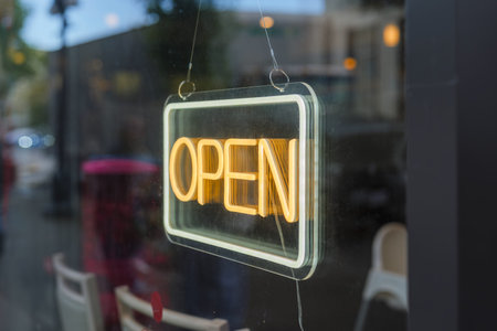 Bright neon 'OPEN' sign glowing in shop window.