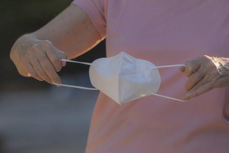 A real woman teaches how to put on the protective mask to prevent the spread of the COVID-19 virus...
