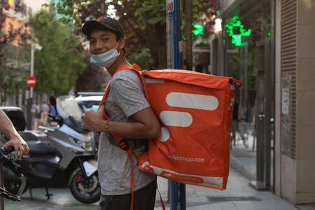 Madrid, Spain - May 19, 2020: Delivery people from the home delivery company, fasttiapp, working on the streets of Madrid, delivering food and staff.のeditorial素材