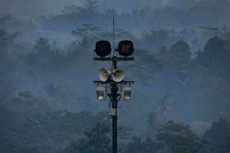 Borobudur temple, Indonesia - July 18, 2019: A pole with loudspeakers and light bulbs installed to announce public address messages and prayers to temple visitors.のeditorial素材