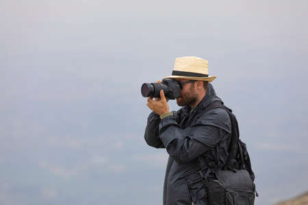 A young man enjoys taking photos in nature on his way to the cold summit of Moncayo, the highest mountain in the Iberian System, in the Tarazona region of Aragon, Spain.の写真素材