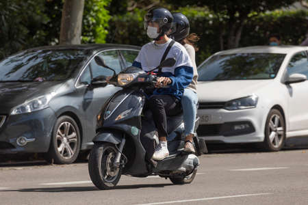 Madrid, Spain - Sep 26, 2020: A young boy and girl, wearing a helmet and a protective face mask,...