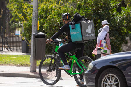 Madrid, Spain - Sep 26, 2020: Delivery people from the home delivery company, Deliveroo, working on...