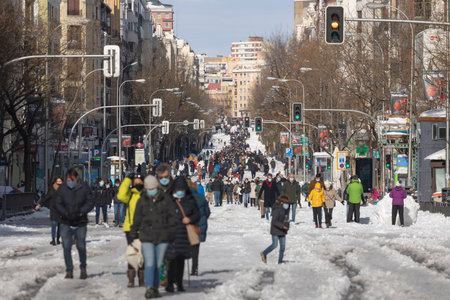 Madrid, Spain - January 10, 2021: General view of Narvaez street, full of people enjoying the sun and snow after the storm, on a snowy day, due to the Filomena polar cold front.のeditorial素材