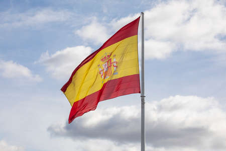 Madrid, Spain - Feb 07, 2021: Flag of Spain, fluttering in the wind attached to a huge white flagpole, silhouetted against the sunset sky, in Plaza Colon, downtown area.のeditorial素材