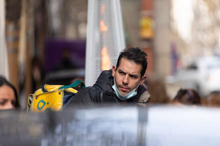 Madrid, Spain - Feb 07, 2021: Delivery people from the home delivery company, Glovo, working on the...