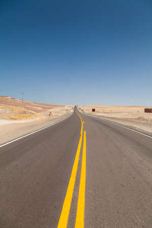 Yellow lines painted in a road, a lonely, desert and scorching place, in the Paracas Peninsula, near Ica, on the road to Pisco, in Peru, South America.の写真素材