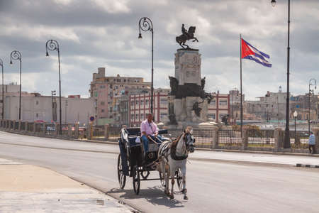 Havana, Cuba - March 23, 2010: A carriage pulled by a white horse crosses the road, near the Malecon, at the height of the Antonio Maceo Park, in the Havana Centro area.のeditorial素材
