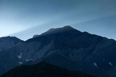 First light of dawn over the solitary mountains in summer, under a clean and huge blue sky, Aragonese Pyrenees, Huesca province, Posets-Maladeta Natural Park.の写真素材