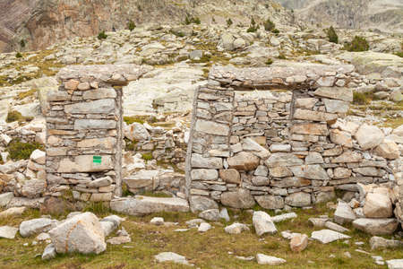 Ruins of an old stone building, part of one of the old shelters that can be found on the way to the mountain lakes in the Aragonese Pyrenees, Huesca, Posets-Maladeta Natural Park.の写真素材