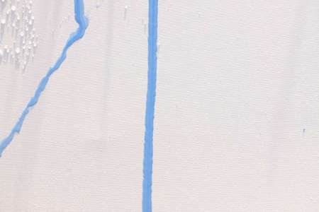 Blue paint and water dripping onto a blank canvas in the evening light. Exercises of artistic expression and painting in the open air, outside the home.の写真素材