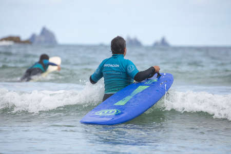 Galicia, Spain - August 2, 2020: Surf lessons on the beach of San Antonio, Espasante. Novice...