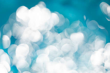 Waves, reflections, refractions and abstract diffractions with bokeh effect, in the blue and crystalline water, of a swimming pool in the municipality of Gallur, Aragon, Spain, on a summer day.の写真素材