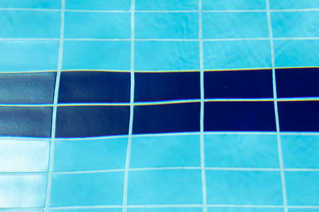 Ripples and reflections in the crystal clear blue water between the lanes of a swimming pool in the municipality of Gallur, Aragon, Spain, on a summer day.の写真素材