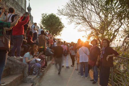 Luang Prabang, Laos - December 14, 2020: Crowds of tourists and local people huddle atop the Phousi...