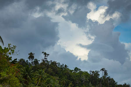 Gray clouds over the rainforest of Gam Island, herald the upcoming rains over the Raja Ampat archipelago, West Papua, Indonesiaの写真素材