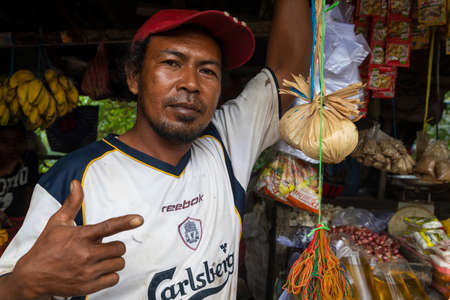 Waisai, Indonesia - Oct 16, 2019: A vendor greets me from his stall selling food at the local market in Waisai, Raja Ampat, Indonesiaのeditorial素材