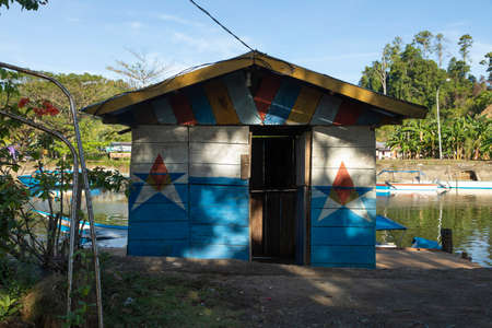 Waisai, Indonesia - Oct 17, 2019: A humble little wooden construction, painted decoratively, used as shelter when it rainsのeditorial素材