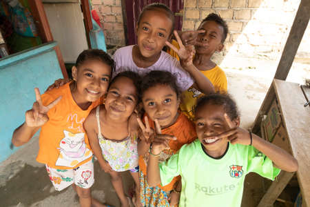 A group of small girls, full of joy, pose and greet me, in a neighborhood of Sorong, to the west of...
