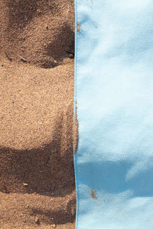 Texture of sand and towel cloth, of intense color, extended to the sun, on Arrigunaga beach, near...