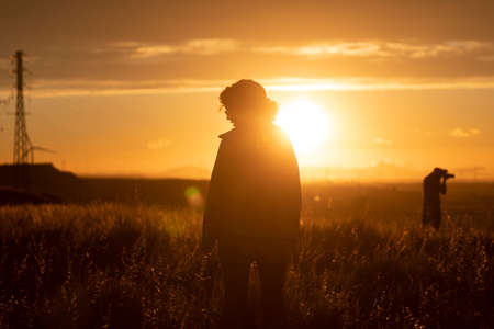The silhouette of a young woman, formed by the last orange sun rays, in Gallur, Aragon, Spainの写真素材