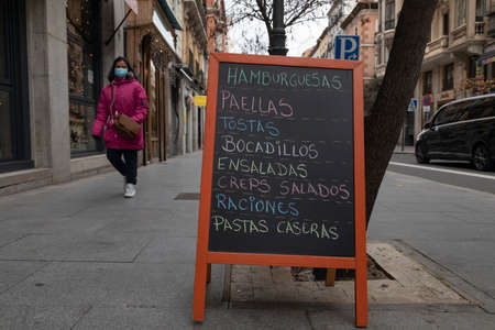 Madrid, Spain - Dec 27, 2020: Poster advertisement with the menu of a bar or restaurant, written with colored chalk, in the Calle Mayor of Madrid, downtown areaのeditorial素材