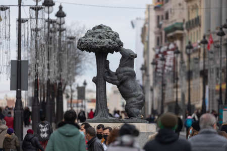 Madrid, Spain - Dec 27, 2020: The famous statue of the bear and the strawberry tree, in Puerta del Sol, surrounded by dozens of people on a cold winter afternoonのeditorial素材