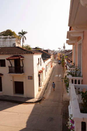 Cartagena de Indias, Colombia - Nov 21, 2010: A woman walks alone through one of the streets of the historic center of the city, among typical buildings of the colonial eraのeditorial素材