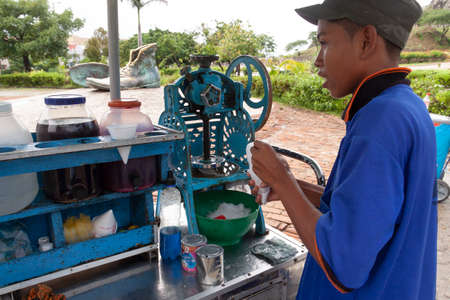Cartagena de Indias, Colombia - Nov 21, 2010: A young boy works preparing ice creams, flavored ice slushies and soft drinks at a street stall in the Plaza de Los Zapatos Viejosのeditorial素材