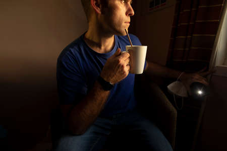Watching from the window, how time slips away, self isolate, drinking some tea in a hotel room, near Manchester airport, United Kingdom, while I wait for the results of a covid-19 pcr testの写真素材