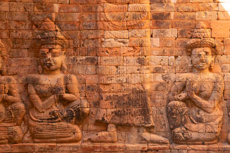 Relief on a wall, representation of two kneeling figures praying, in Prasat Kravan, a Hindu temple of the 10th century, in the Angkor Archaeological Park, near Siem Reap, northwest, Cambodiaの写真素材