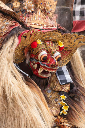 A dancing artist, disguised as a Barong, demonstrates about the mythological depiction of animals that have supernatural powers and could protect humansの写真素材