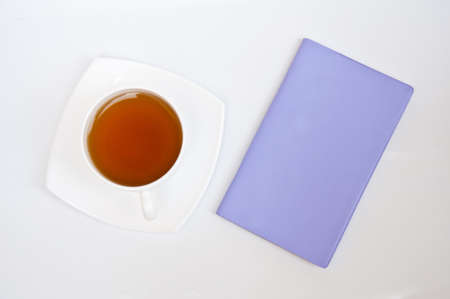 tea and violet  notebook on white backgroundの写真素材