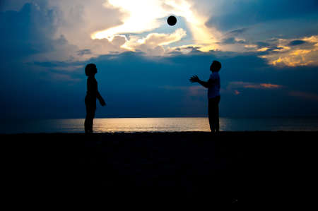 silhouette of family play on the beach together in the morningの写真素材