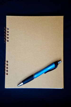 Golden paper and pen on black background