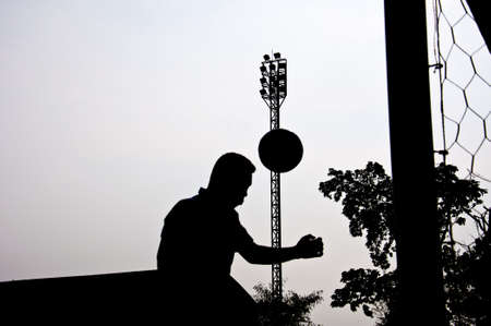 silhouette of football player heading for goalの写真素材