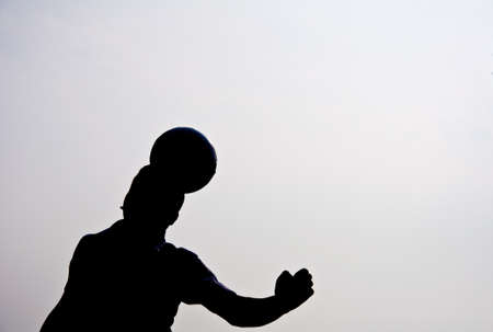 silhouette of football player heading for goalの写真素材