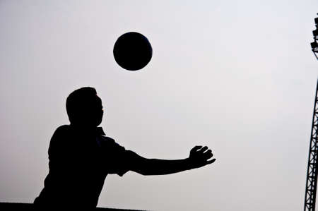 silhouette of football player heading for goalの写真素材