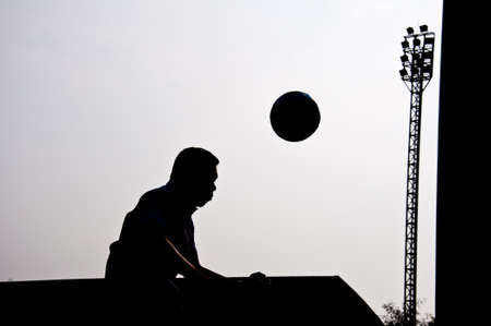 silhouette of football player heading for goalの写真素材