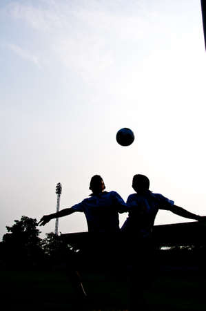 silhouette of football player heading for goalの写真素材